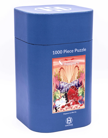 A blue cylindrical puzzle box for a 1000-piece Singapore-themed puzzle, featuring a colorful illustration of a red elephant and tropical scenery on the front, with the HAUKEG brand logo at the bottom.